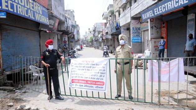 Security personnel stand guard next to a barricade marking the Pili Sadak coronavirus containment zone in Patiala on August 11. India also saw its Covid-19 tally jump by 66,999 new cases--the highest single-day spike--recorded in the same period, which pushed the number of cases to nearly 2.4 million. (Bharat Bhushan / HT Photo)