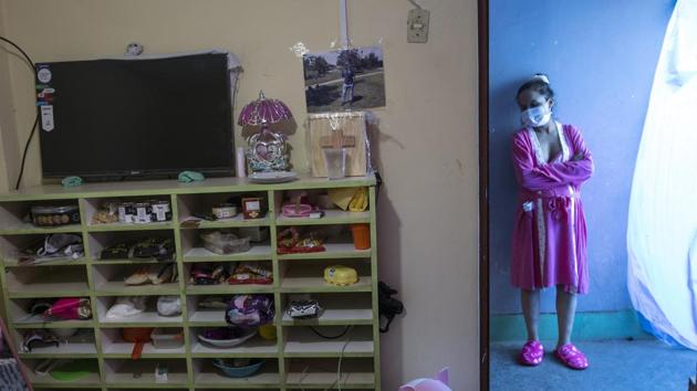 Maria Alvarez, 24, stands near a window next to a room where a wooden box adorned with a pink coloured cross that contain the cremated remains of her husband who died from the new coronavirus in June, sits on a shelf in the home of friend who has offered her a place to stay, in Lima, Peru, Thursday, July 30, 2020. Maria, who had an asymptomatic case of COVID-19, gave birth to her first child the day before at the National Perinatal and Maternal Institute in a special ward for mothers infected with the virus.(AP)