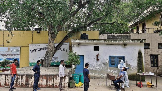 People wait for their swab samples to be collected at a testing centre in Daryaganj. People wait for their swab samples to be collected at a testing centre in Daryaganj.
