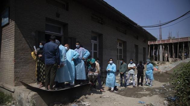 Relatives and bystanders, some of them wearing protective suits line up to get oxygen cylinders for patients outside a hospital in Srinagar on August 12. India is currently managing 668,220 active cases of Covid-19 infection meanwhile 1,808,936 patients admitted with the disease have been cured or discharged from hospitals, HT reported. (Mukhtar Khan / AP) Relatives and bystanders, some of them wearing protective suits line up to get oxygen cylinders for patients outside a hospital in Srinagar on August 12. India is currently managing 668,220 active cases of Covid-19 infection meanwhile 1,808,936 patients admitted with the disease have been cured or discharged from hospitals, HT reported. (Mukhtar Khan / AP)