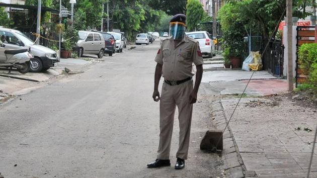 A cop with face shield and masks in a containment zone in Chandigarh on Thursday. (Ravi Kumar/HT) A cop with face shield and masks in a containment zone in Chandigarh on Thursday. (Ravi Kumar/HT)