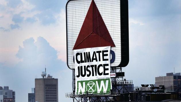 Members of an environmental group hangs a banner that reads “CLIMATE CHANGE NOW” on the iconic Citgo sign near Boston's Fenway Park in Kenmore Square in Boston. (AP) Members of an environmental group hangs a banner that reads “CLIMATE CHANGE NOW” on the iconic Citgo sign near Boston's Fenway Park in Kenmore Square in Boston. (AP)