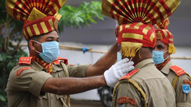 A SSB personnel adjusts the headgear of his colleague during a full dress rehearsal for the 74th Independence Day celebrations at Gandhi Maidan in Patna, on August 13. (A P Dube / HT Photo)