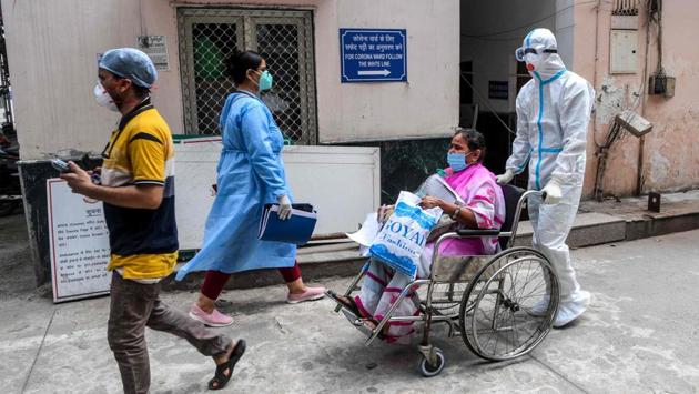 A medical staff wearing a Personal Protective Equipment (PPE) suit (R) shifts a patient in a wheelchair near a COVID-19 coronavirus ward at a hospital in New Delhi on August 12. 956 new deaths were reported on August 15 taking the death count to 49,036. (Prakash Singh / AFP) A medical staff wearing a Personal Protective Equipment (PPE) suit (R) shifts a patient in a wheelchair near a COVID-19 coronavirus ward at a hospital in New Delhi on August 12. 956 new deaths were reported on August 15 taking the death count to 49,036. (Prakash Singh / AFP)