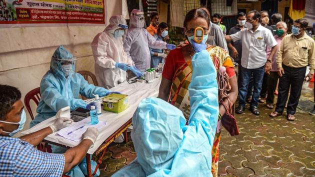 A health worker wearing a Personal Protective Equipment (PPE) suit checks the body temperature of a resident (C) during a (COVID-19) coronavirus screening in Mumbai on August 12. Nearly 27 million tests have been conducted across the country since January 22 when Covid-19 testing started with a single lab at the Indian Council of Medical Research’s (ICMR) National Institute of Virology in Pune. (Indranil Mukherjee / AFP) A health worker wearing a Personal Protective Equipment (PPE) suit checks the body temperature of a resident (C) during a (COVID-19) coronavirus screening in Mumbai on August 12. Nearly 27 million tests have been conducted across the country since January 22 when Covid-19 testing started with a single lab at the Indian Council of Medical Research’s (ICMR) National Institute of Virology in Pune. (Indranil Mukherjee / AFP)