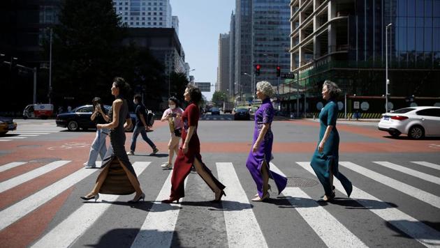 Members of an internet celebrity model group "Glamma Beijing" (L-R), Lin Wei, 65, Sun Yang, 64, Wang Nianwen, 74, and Wang Xinghuo, 70, wearing traditional Chinese dresses walk across a street during a video shooting, following the coronavirus disease (COVID-19) outbreak, in Beijing's Central Business District (CBD) area, China August 13, 2020. (REUTERS)