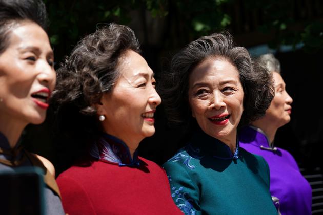 (L-R), Lin Wei, 65, Sun Yang, 64, Wang Xinghuo, 70 and Wang Nianwen, 74, wearing traditional Chinese dresses walk across a street during a video shooting, following the coronavirus disease (COVID-19) outbreak, in Beijing's Central Business District (CBD) area, China August 13, 2020. (REUTERS)