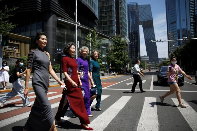 Members of an internet celebrity model group "Glamma Beijing" (L-R), Lin Wei, 65, Sun Yang, 64, Wang Nianwen, 74, and Wang Xinghuo, 70, wearing traditional Chinese dresses walk across a street during a video shooting, following the coronavirus disease (COVID-19) outbreak, in Beijing's Central Business District (CBD) area, China August 13, 2020. (REUTERS)