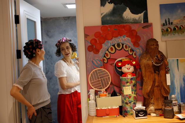 An elderly model group "Glamma Beijing" members Sun Yang (L), 64, and Wang Xinghuo, 70, chat as they prepare their hair for a video shooting, following the coronavirus disease (COVID-19) outbreak, at Sun's home in Beijing, China August 13, 2020. (REUTERS)
