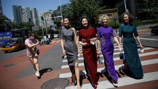 Members of an internet celebrity model group "Glamma Beijing" (L-R), Lin Wei, 65, Sun Yang, 64, Wang Nianwen, 74, and Wang Xinghuo, 70, wearing traditional Chinese dresses walk across a street during a video shooting, following the coronavirus disease (COVID-19) outbreak, in Beijing's Central Business District (CBD) area, China August 13, 2020. (REUTERS)