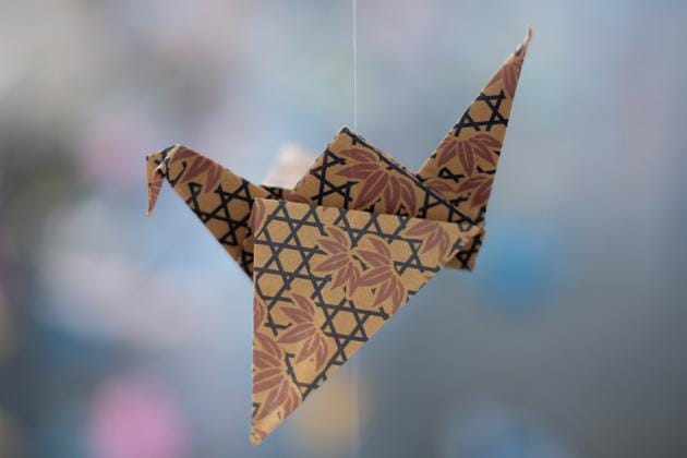 An origami paper crane hangs in the Matter Studio Gallery in Los Angeles, among thousands of others during an exhibit for those who have died in the U.S., of COVID-19, on Tuesday, Aug. 11, 2020. Hundreds of origami now hang from the ceiling of Karla Funderburk’s Matter Studio with others sitting on tables and stacked in boxes waiting to be added to the sad reminder of the virus’ toll. (AP Photo/Richard Vogel) (AP)