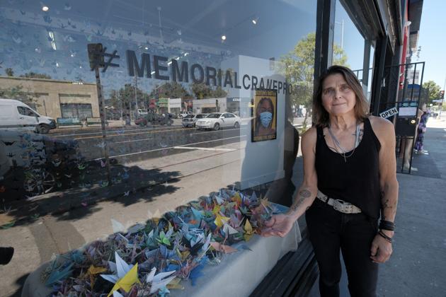 Artist Karla Funderburk, owner of Matter Studio Gallery, poses outside her gallery displaying a window of origami paper cranes during an exhibit "Honoring Matter, A Memorial for the Victims of COVID-19," in Los Angeles, Tuesday, Aug. 11, 2020. (AP Photo/Richard Vogel) (AP)
