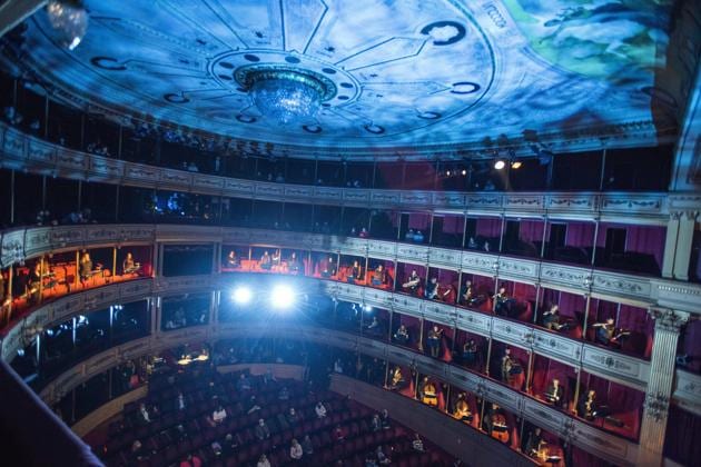 People wearing face masks amid the new coronavirus pandemic listen as musicians of the Montevideo Philharmonic Band perform at the Solis theatre in Montevideo, Uruguay, Thursday, Aug. 13, 2020. Five months after all the live arts shows were canceled due to the pandemic, the Solis theatre reopened today for a public performance. (AP Photo/Matilde Campodonico) (AP)