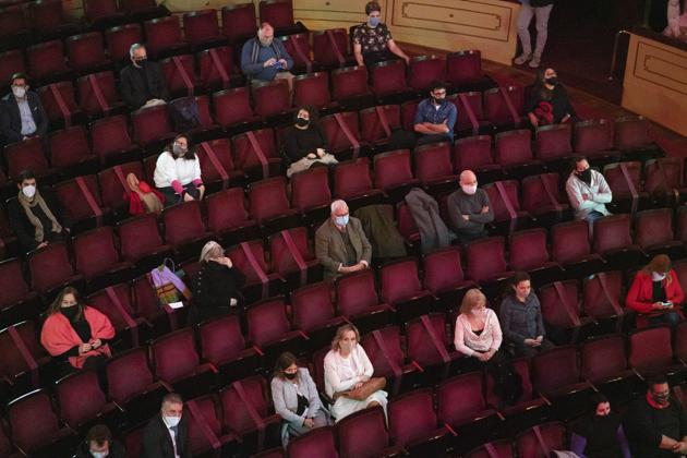 People wearing face masks and keeping a safe distance from each other amid the new coronavirus pandemic attend a concert by the Montevideo Symphonic Band at the Solis theatre in Montevideo, Uruguay, Thursday, Aug. 13, 2020. Five months after all the live arts shows were canceled due to the pandemic, the Solis theatre reopened today for a public performance. (AP Photo/Matilde Campodonico) (AP)