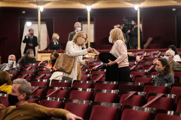 Patrons wearing face masks bump their fists as a greeting amid the new coronavirus pandemic before a concert by the Montevideo Symphonic Band at the Solis theatre in Montevideo, Uruguay, Thursday, Aug. 13, 2020. Five months after all the live arts shows were canceled due to the pandemic, the Solis theatre reopened today for a public performance. (AP Photo/Matilde Campodonico) (AP)