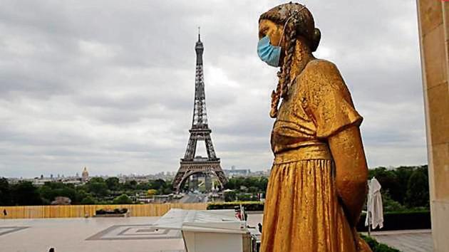 A mask is put on a statue next to Trocadero Square close to the Eiffel Tower in Paris.