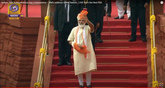 The PM wore his trademark light cream coloured half-sleeved kurta and churidar combo. However, keeping in view of the current situation created by COVID-19, he has added a scarf, like a mask in white colour having orange borders (not pictured). (YouTube/Doordarshan National)