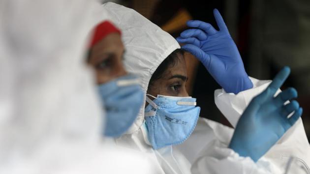 A health worker adjusts her personal protective equipment (PPE) during a check up campaign for the coronavirus disease (COVID-19) in Mumbai.(REUTERS)