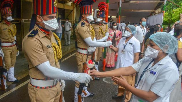 Police personnel and medics greet each other with flowers while celebrating the 74th Independence Day amid COVID-19 pandemic at the Civil Hospital in Thane on August 15. (PTI) 