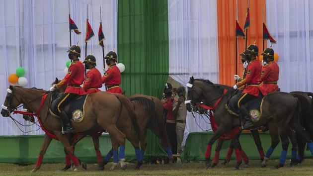 Policemen watch the Independence Day parade from behind a partition as mounted police personnel pass them by in Guwahati on August 15. (Anupam Nath / AP) 