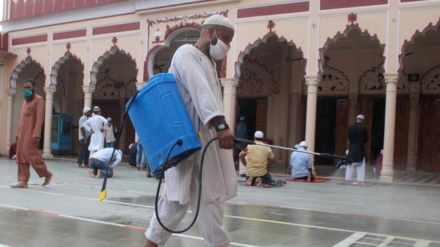 A worker sprays disinfectant as devotees arrive to offer prayers at Jama Masjid , during unlock 3.0, in Gurugram, on Friday.(PTI)