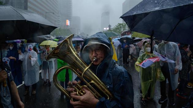A protester plays a tuba during the anti-government protest in Seoul on August 15. The protests came as the government moved to impose stronger social distancing restrictions in the city and nearby towns following a spike in coronavirus infections. (Ed Jones / AFP)