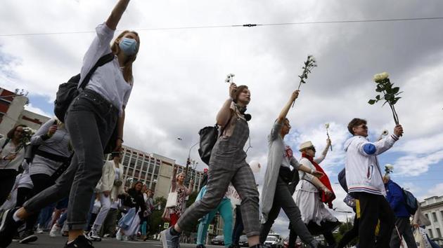 Belarusian women carry flowers on a rally in solidarity with protesters injured in the latest rallies against the results of the country's presidential election in Minsk, Belarus.(AP)