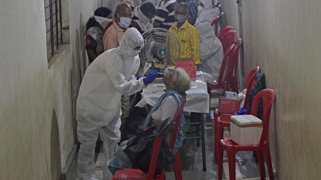 Health care staff collect swab sample of residents of Omkar SRA at Malad (E) as part of Covid-19 tests in Mumbai on Sunday,.(Satyabrata Tripathy/HT Photo) Health care staff collect swab sample of residents of Omkar SRA at Malad (E) as part of Covid-19 tests in Mumbai on Sunday,.(Satyabrata Tripathy/HT Photo)