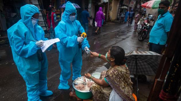 Health care workers screen a fishmonger for temperature and blood oxygen saturation during door to door screening at Dharavi in Mumbai on August 14. India is ranked third in the number of infections — only the US and Brazil have recorded more cases than India and have substantially higher death tolls from the viral illness. (Pratik Chorge / HT Photo)