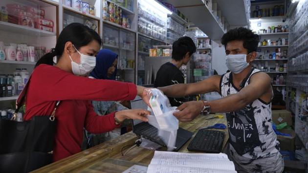 A girl buys surgical masks which are in high demand due to Covid-19 situation in Imphal. (AP) A girl buys surgical masks which are in high demand due to Covid-19 situation in Imphal. (AP)