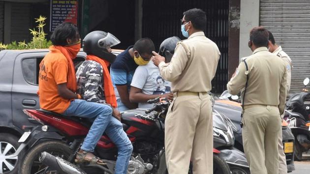 Police personnels screening motorists for lockdown restriction violations, at MG road in Ranchi.(HT photo)