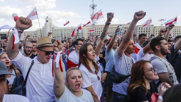 People with old Belarusian national flags shout during opposition rally in front of the government building of Minsk, Belarus on Sunday. (AP Photo)