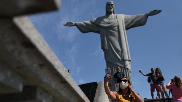 Tourists take photos at the Christ the Redeemer statue during the reopening after months-long closure due to the outbreak of the coronavirus disease (COVID-19), in Rio de Janeiro, Brazil August 15, 2020. (REUTERS/Pilar Olivares)