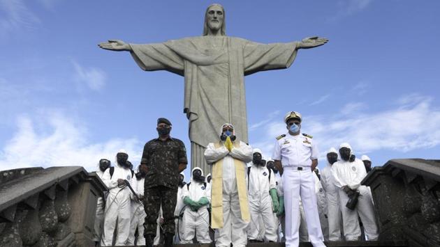 Catholic priest Omar is pictured with military members during disinfection works on Christ the Redeemer statue, ahead of its re-opening amid the coronavirus disease (COVID-19) outbreak, in Rio de Janeiro, Brazil, August 13, 2020. (REUTERS/Ricardo Moraes)