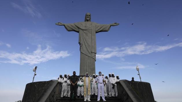 Catholic Priest Omar prays with Military members during a disinfection of the Christ the Redeemer statue ahead of its re-opening amid the coronavirus disease (COVID-19) outbreak, in Rio de Janeiro, Brazil, August 13, 2020. (REUTERS/Ricardo Moraes)