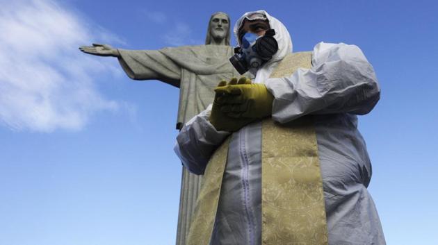 Catholic Priest Omar is pictured as Military members work on disinfection of the Christ the Redeemer statue ahead of its re-opening amid the coronavirus disease (COVID-19) outbreak, in Rio de Janeiro, Brazil, August 13, 2020. (REUTERS/Ricardo Moraes)