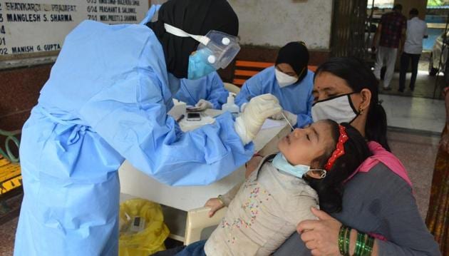 Health care worker collect swab sample of a resident at Mansarovar, Bhiwandi.(Praful Gangurde/ HT Photo)