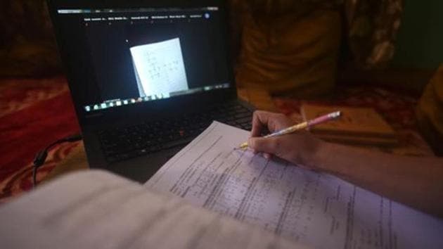 A student takes note while attending an online class at her home in Srinagar.(Waseem AndrabiHT Photo)