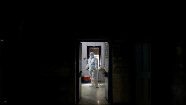 A health worker in personal protective equipment (PPE) waits at a local health centre for the next person to be tested for the coronavirus disease (Covid-19), amid the spread of the disease.(REUTERS)