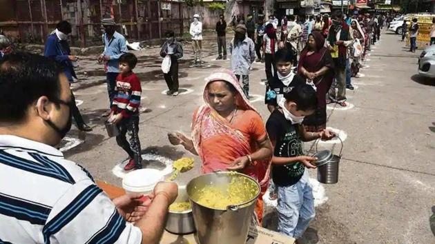 Homeless persons and stranded migrant workers queue up to receive food in designated spots maintaining social distancing at Ramakrishna Ashram, in New Delhi on March 27, 2020.(Vipin Kumar / HT File Photo)