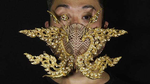 Edmond Kok, a Hong Kong theater costume designer and actor, wearing a face mask inspired by the decoration of Thai temple to Kok's face in Hong Kong. (AP Photo/Vincent Yu) Edmond Kok, a Hong Kong theater costume designer and actor, wearing a face mask inspired by the decoration of Thai temple to Kok's face in Hong Kong. (AP Photo/Vincent Yu)