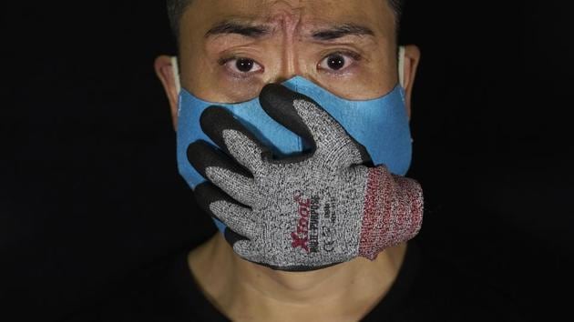 Edmond Kok, a Hong Kong theater costume designer and actor, wearing a face mask designed with a stuffed glove stuck on it, representing a hand over his mouth, looking scared, in Hong Kong Thursday, Aug. 6, 2020. (AP Photo/Vincent Yu) Edmond Kok, a Hong Kong theater costume designer and actor, wearing a face mask designed with a stuffed glove stuck on it, representing a hand over his mouth, looking scared, in Hong Kong Thursday, Aug. 6, 2020. (AP Photo/Vincent Yu)