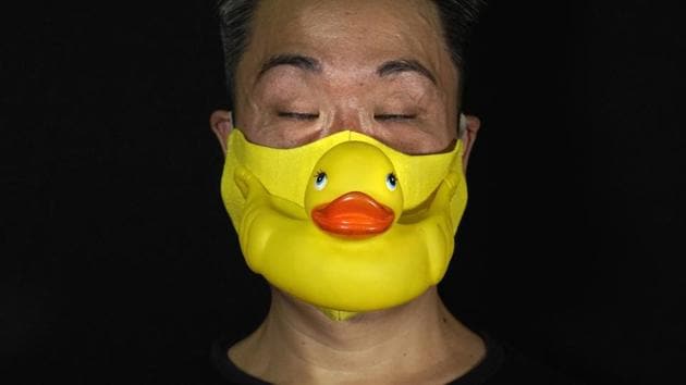 Edmond Kok, a Hong Kong theater costume designer and actor, wearing a face mask made by a rubber yellow duck in Hong Kong Thursday, Aug. 6, 2020. (AP Photo/Vincent Yu) Edmond Kok, a Hong Kong theater costume designer and actor, wearing a face mask made by a rubber yellow duck in Hong Kong Thursday, Aug. 6, 2020. (AP Photo/Vincent Yu)