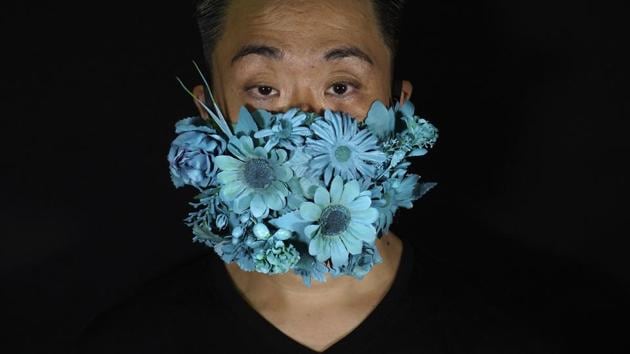 Edmond Kok, a Hong Kong theater costume designer and actor, wearing a face mask covered in blue artificial flowers which he made on Valentine's Day this February in Hong Kong Thursday, Aug. 6, 2020. (AP Photo/Vincent Yu) Edmond Kok, a Hong Kong theater costume designer and actor, wearing a face mask covered in blue artificial flowers which he made on Valentine's Day this February in Hong Kong Thursday, Aug. 6, 2020. (AP Photo/Vincent Yu)