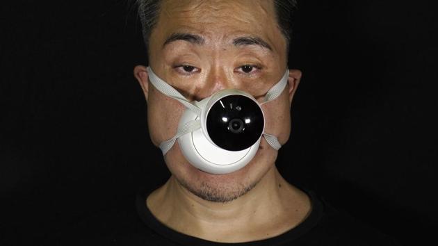 Edmond Kok, a Hong Kong theater costume designer and actor, wearing a face mask with a model CCTV (close circuit television) mounted on it in Hong Kong Thursday, Aug. 6, 2020. (AP Photo/Vincent Yu) Edmond Kok, a Hong Kong theater costume designer and actor, wearing a face mask with a model CCTV (close circuit television) mounted on it in Hong Kong Thursday, Aug. 6, 2020. (AP Photo/Vincent Yu)