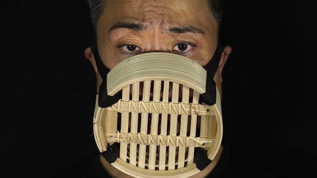 Edmond Kok, a Hong Kong theater costume designer and actor, wearing a face mask made from Chinese bamboo steamer in Hong Kong. (AP Photo/Vincent Yu) Edmond Kok, a Hong Kong theater costume designer and actor, wearing a face mask made from Chinese bamboo steamer in Hong Kong. (AP Photo/Vincent Yu)