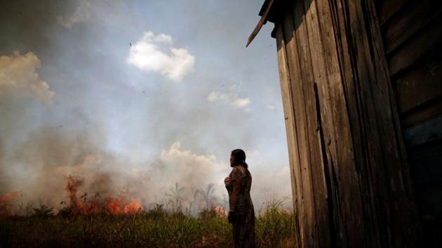 Miraceli de Oliveira reacts as the fire approaches their house in an area of the Amazon rainforest, near Porto Velho, Rondonia State, Brazil.(REUTERS)