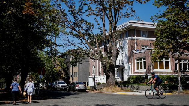 People walk and bike in the Greek Row area at the University of Washington in Seattle, Washington, US. (REUTERS) People walk and bike in the Greek Row area at the University of Washington in Seattle, Washington, US. (REUTERS)