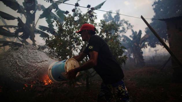 Bricklayer Rosalino de Oliveira tries to douse a fire to protect his house near Porto Velho in the State of Rondonia on August 16. Experts say the fires that threaten the world’s largest rainforest are rarely a natural phenomenon and are mostly set deliberately by speculators to clear land for pasture. (Ueslei Marcelino / REUTERS)
