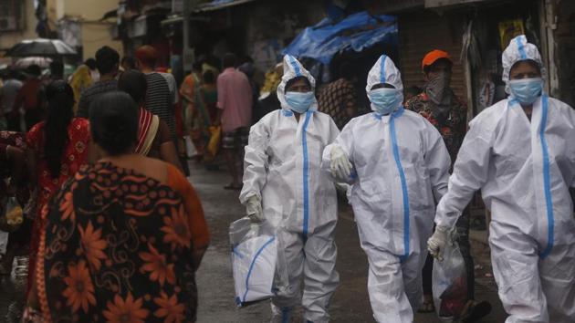 Health workers return after screening people for Covid-19 symptoms in Dharavi, one of Asia's biggest slums, in Mumbai. (AP) Health workers return after screening people for Covid-19 symptoms in Dharavi, one of Asia's biggest slums, in Mumbai. (AP)